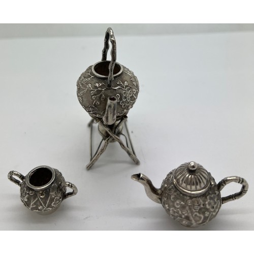 591 - Miniature Chinese silver teapot, kettle on stand and sugar bowl with prunus blossom decoration marke... 