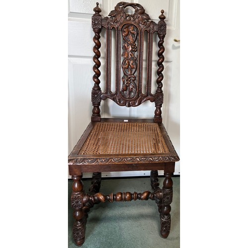 1310 - A carved oak single chair with cane seat