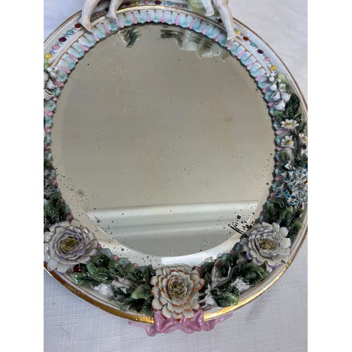 228 - Continental porcelain framed mirror with putti and floral decoration 34cm x 26cm.