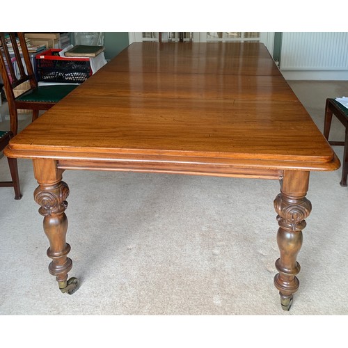 1322 - A Victorian mahogany dining table with 2 extra leaves on brass castors and carved turned legs. 215 x... 