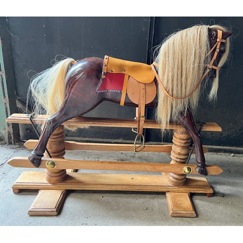 759 - A good quality wooden rocking horse with leather saddle, bridle etc. Horse 101cm w.