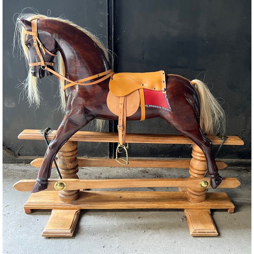 759 - A good quality wooden rocking horse with leather saddle, bridle etc. Horse 101cm w.