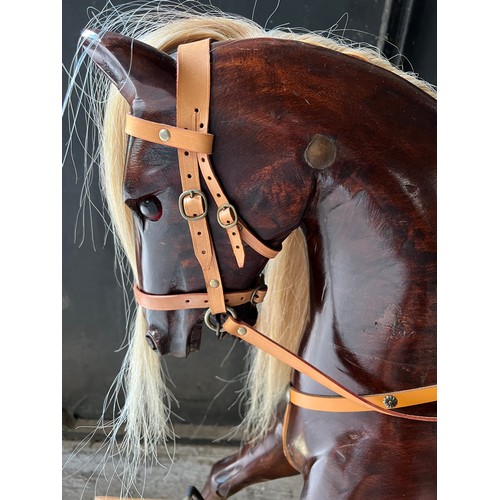 759 - A good quality wooden rocking horse with leather saddle, bridle etc. Horse 101cm w.