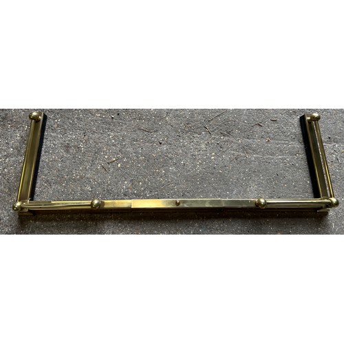 1329 - An extendable brass fender. Maximum internal 154 w x 38cm d.