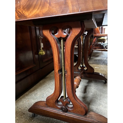 1332 - A mahogany 2 drawer side table on castors with decorative side supports and brass columns. 67 w x 55... 