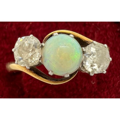 389 - An 18ct gold ring set with central opal and diamonds to either side. Size R, 4.5gm.