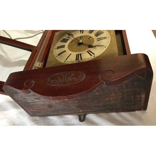 832 - Mahogany wall mounted clock with roman numerals on clock face. Believed to be working order, winds u... 