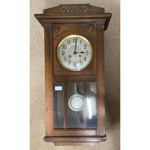 840 - An oak cased wall clock. 80cm h.