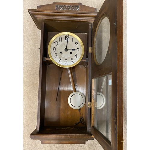 840 - An oak cased wall clock. 80cm h.