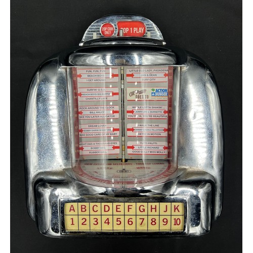 815A - A miniature coin operated wall mounted chrome jukebox. 35cm h x 31cm w.