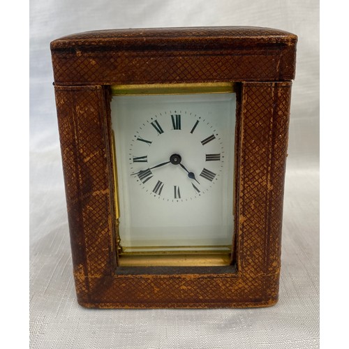 802 - A brass carriage clock with Swiss movement. 14cms h with handle up. Key included. Winds and goes. In... 