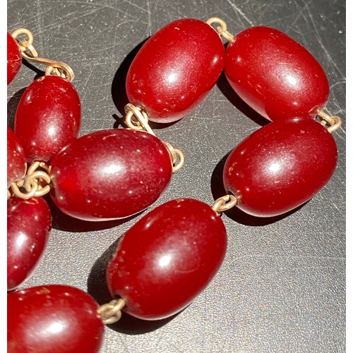 378 - A quantity of cherry amber beads to include 2 necklaces and other loose beads. 164gm total weight.