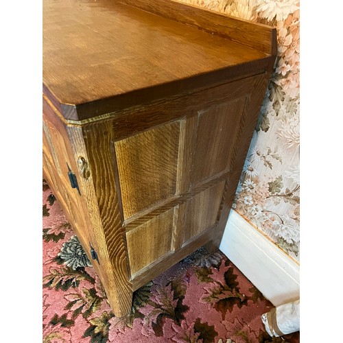 175 - Peter Heap Rabbitman, An Oak Panelled Sideboard, with raised upstand above two cupboard doors enclos... 