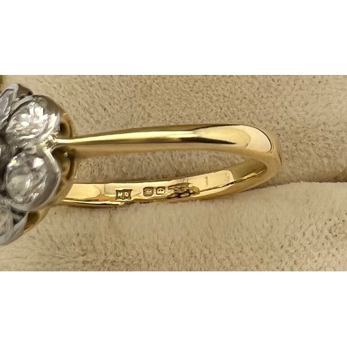 635 - An 18ct gold ring set with diamonds to form a six petalled flower. Size N. Weight 3.2gm.