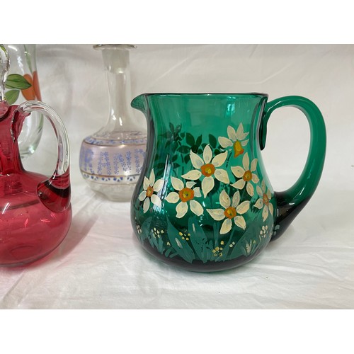 476 - A selection of coloured and hand painted glass ware to include: 3 x cranberry jugs, 3 x green jugs a... 