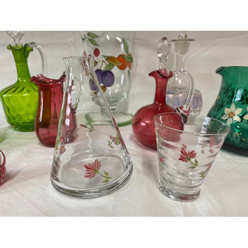 476 - A selection of coloured and hand painted glass ware to include: 3 x cranberry jugs, 3 x green jugs a... 