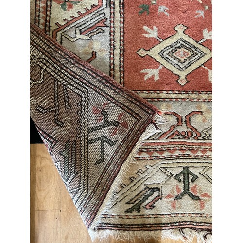 1126 - A vintage wool rug in shades of orange. 246 w x 170cm d.