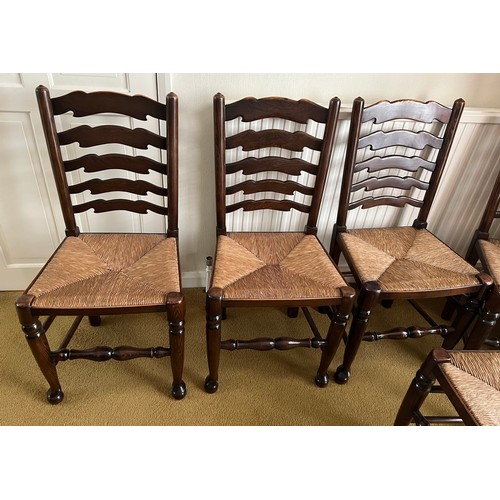 149 - Six oak ladder backed chairs with rush seats.