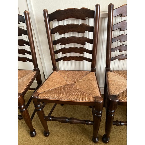 149 - Six oak ladder backed chairs with rush seats.