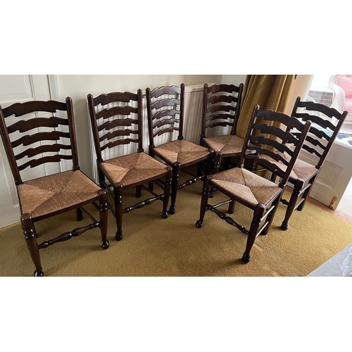 149 - Six oak ladder backed chairs with rush seats.