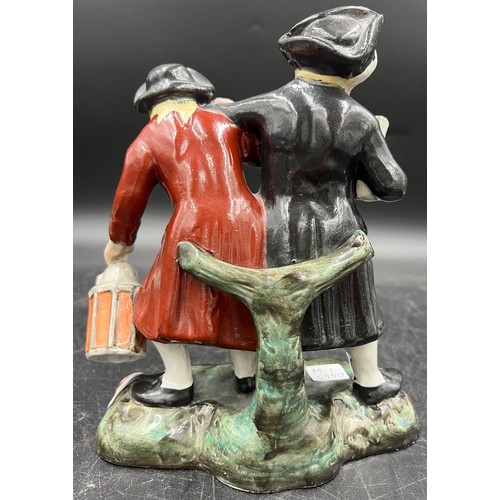 455 - A Staffordshire figure depicting two men appearing to be returning from a good night out. 21.5cm h.