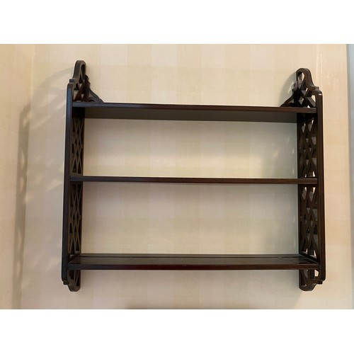 199 - A mahogany wall shelf with fretted sides. Marked R. Armstrong to base.