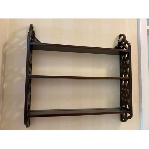 199 - A mahogany wall shelf with fretted sides. Marked R. Armstrong to base.