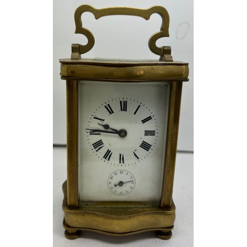 1035 - Brass carriage alarm clock with serpentine shaped case with French movement.