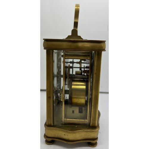 1035 - Brass carriage alarm clock with serpentine shaped case with French movement.