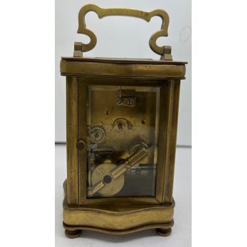 1035 - Brass carriage alarm clock with serpentine shaped case with French movement.