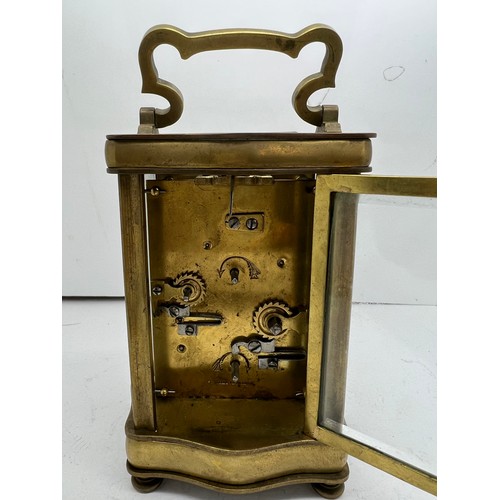 1035 - Brass carriage alarm clock with serpentine shaped case with French movement.