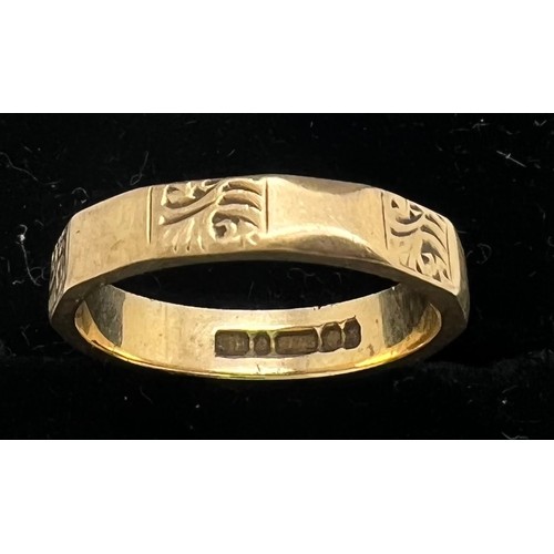 581 - A 9ct gold band. Weight 2.7gm. Size L with engraved decoration.