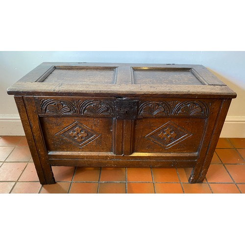 127 - A late 17thC/early 18thC small oak coffer with sunken two panel lid above carved frieze and carved p... 