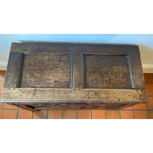 127 - A late 17thC/early 18thC small oak coffer with sunken two panel lid above carved frieze and carved p... 