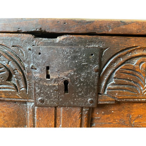 127 - A late 17thC/early 18thC small oak coffer with sunken two panel lid above carved frieze and carved p... 