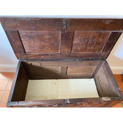 127 - A late 17thC/early 18thC small oak coffer with sunken two panel lid above carved frieze and carved p... 