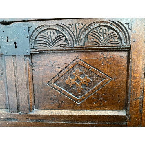 127 - A late 17thC/early 18thC small oak coffer with sunken two panel lid above carved frieze and carved p... 