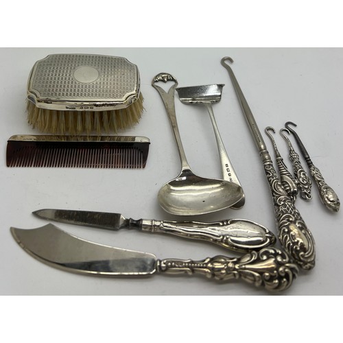 888 - Small hallmarked silver items to include button hooks, spoon and pusher, baby brush and comb. Variou... 