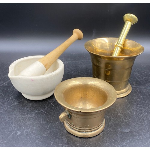 940 - Two brass mortars and a brass pestle together with a 20thC ceramic pestle and mortar, the mortar imp... 