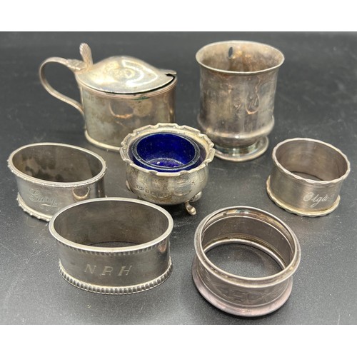 872 - Silver, various dates and makers to include: four napkin rings, a mustard pot, a salt and a mug lack... 