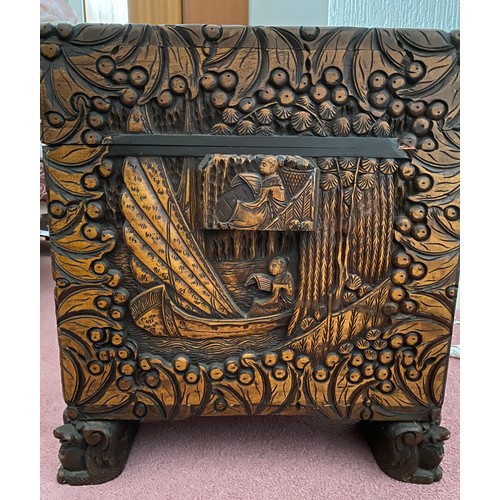 80 - A heavily carved oriental camphor wood chest raised on carved lions. Brass fastening to front. 96 w ... 