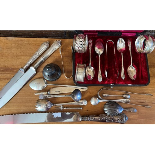 802 - A quantity of hallmarked silver to include 3 napkin rings, silver handled knives, sugar tongs, sugar... 