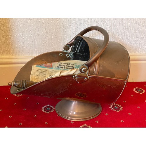 942 - A 19thC copper coal helmet with a copper and wooden shovel and brass tongs.