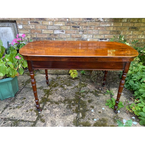 74 - Mahogany inlaid side table on turned legs with castors. Measuring 74cm h, 122cm w,  60 cm d.