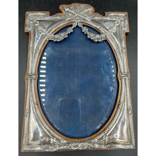 804 - Decorative oval silver photograph frame on wooden back Chester 1909, makers mark rubbed. 29 x 22cm. ... 