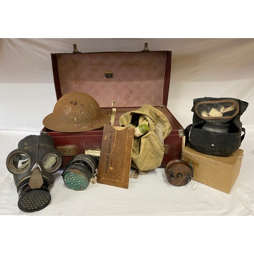 1010 - A suitcase containing 3 gas masks, two in original bags, WW II original helmet, eye shields, anti ga... 