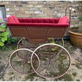 A 19thC wood and iron pram with ceramic handle with recently upholstered interior. 93 l x 48cm w.