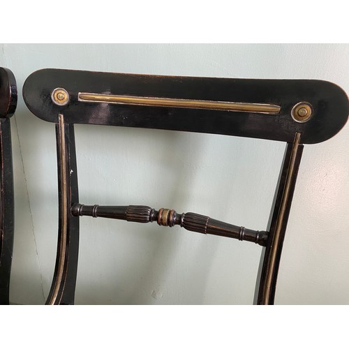 39 - A pair of ebonised Trafalgar chairs maker N T Osbourne. Cane seats, brass inlay and sabre legs to fr... 