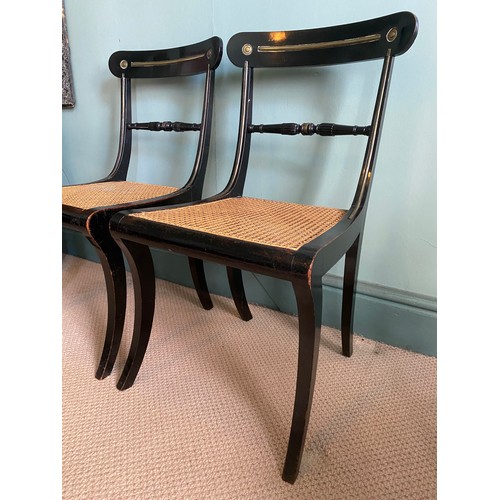 39 - A pair of ebonised Trafalgar chairs maker N T Osbourne. Cane seats, brass inlay and sabre legs to fr... 