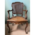A caned armchair in the French style with carved cabriole front legs. 101 h x 60cm w.